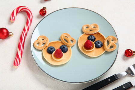 Plate with pancakes in the shape of reindeers on white background. Christmas celebrationの写真素材
