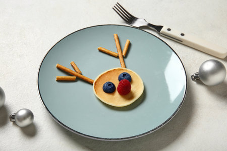 Plate with pancake in shape of reindeer on white background. Christmas celebrationの写真素材