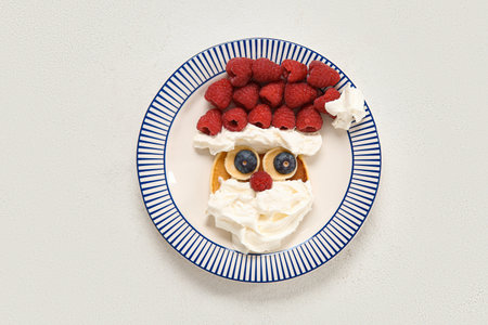 Plate with pancake in the shape of Santa on white background. Christmas celebrationの写真素材