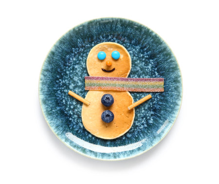 Plate with pancakes in the shape of snowman on white background. Christmas celebrationの写真素材