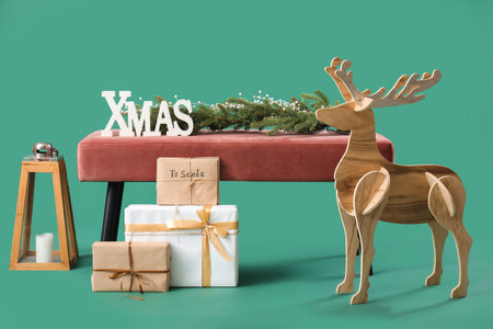 Soft bench with Christmas decor and presents on green backgroundの写真素材