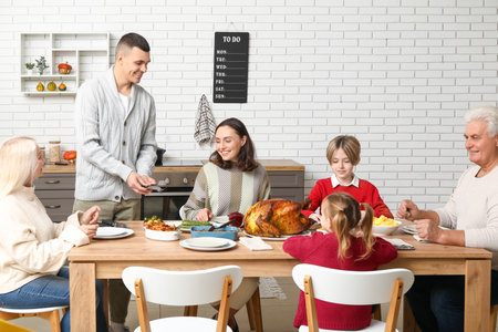 Happy family having dinner at festive table on Thanksgiving Dayの写真素材