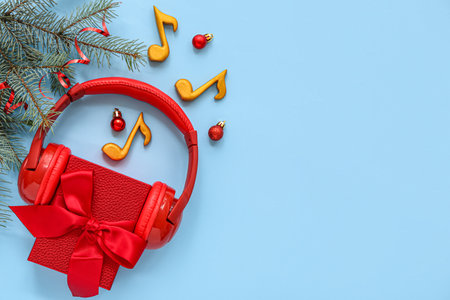 Gift box with headphones and Christmas decor on blue backgroundの写真素材