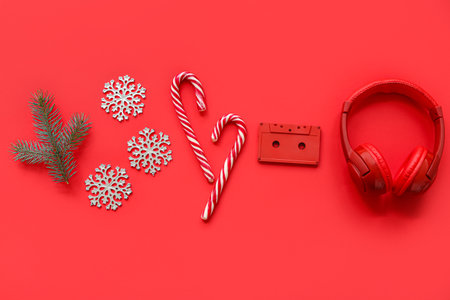 Headphones with audio cassette and Christmas decor on red backgroundの写真素材