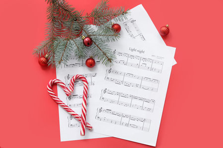 Music note sheets with Christmas decor on red backgroundの写真素材