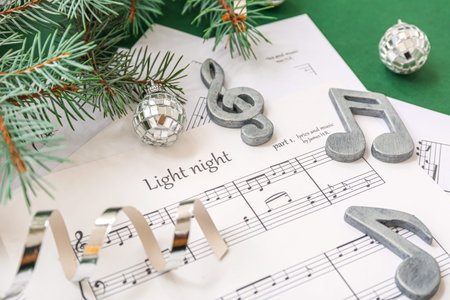 Music note sheets with Christmas decor on green backgroundの写真素材