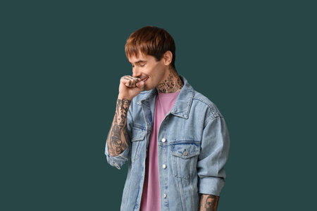 Handsome smiling young man on dark green backgroundの写真素材