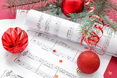 Music note sheets with Christmas decor on red backgroundの写真素材