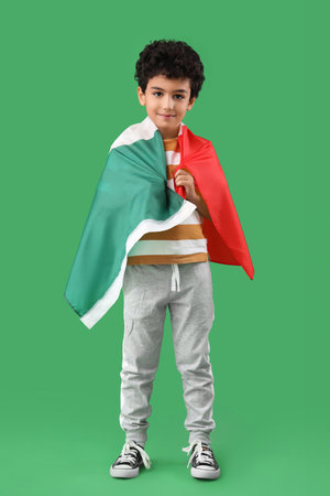 Little boy with Mexican flag on green backgroundの写真素材