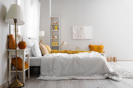 Interior of light bedroom with pumpkins and lampsの写真素材