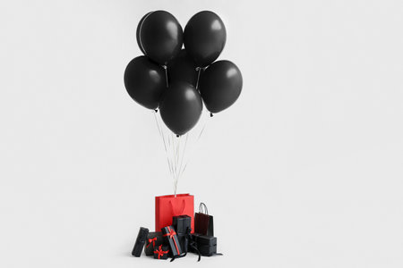 Shopping bags with gift boxes and air balloons on white background. Black Friday saleの写真素材