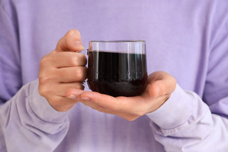 Man holding glass of coffee, closeup