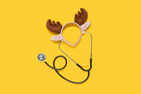 Stethoscope and Christmas reindeer horns on yellow backgroundの写真素材