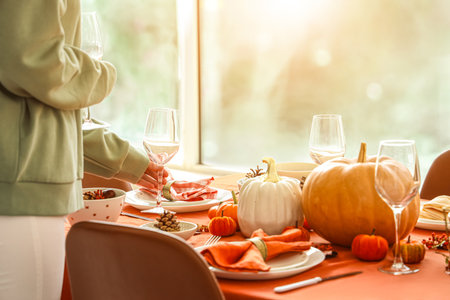 Woman decorating table for Thanksgiving dinner in modern dining room, closeupの写真素材