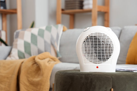 Electric fan heater on ottoman in living room, closeupの写真素材
