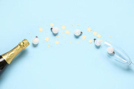 Champagne bottle with glass and Christmas decor on blue backgroundの写真素材