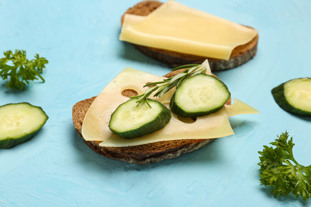 Tasty sandwiches with cheese and cucumber on blue background, closeupの写真素材