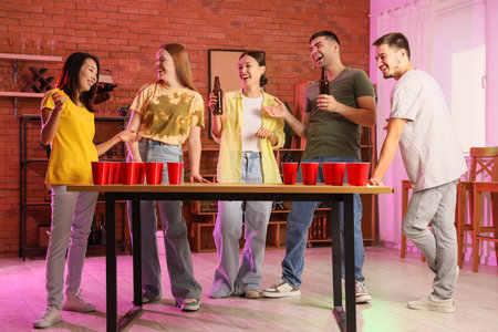 Group of young friends playing beer pong at partyの写真素材