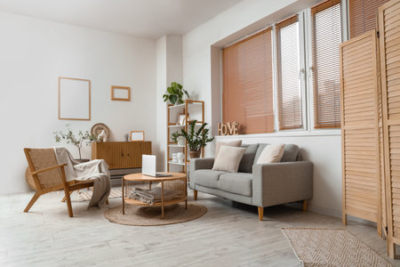 Interior of modern living room with gray sofa, armchair and laptop on coffee tableの写真素材
