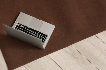 Laptop on fitness mat in room, top viewの写真素材