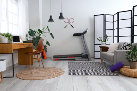 Interior of living room with sports equipment, sofa and workplaceの写真素材