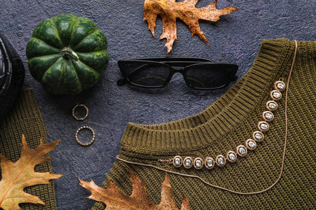 Composition with stylish female accessories, clothes and autumn decor on dark background, closeupの写真素材