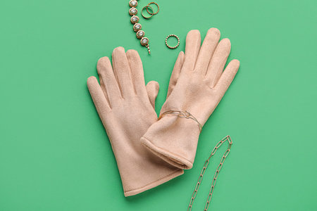 Composition with warm female gloves and accessories on green backgroundの写真素材
