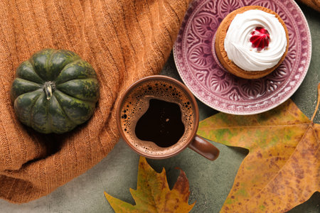 Composition with cup of aromatic coffee, tasty cake and autumn decor on grunge backgroundの写真素材
