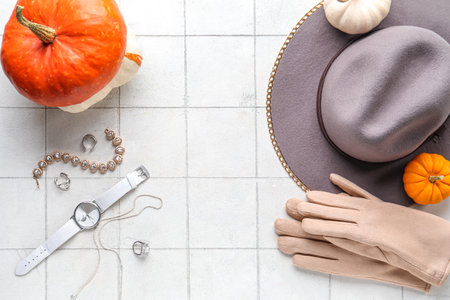 Composition with stylish female accessories and pumpkins on light tile backgroundの写真素材
