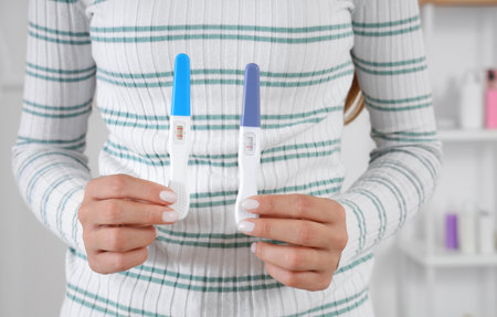 Young lesbian woman with pregnancy tests in bathroom, closeupの写真素材