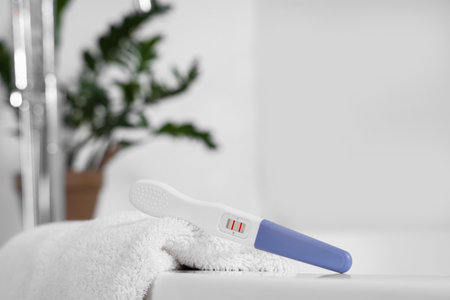 Positive pregnancy test and towel in bathroom, closeupの写真素材