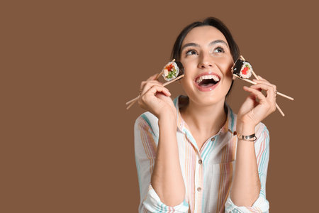 Happy young woman with different sushi on brown backgroundの写真素材