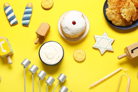 Hannukah composition with menorah, donut and dreidels on yellow backgroundの写真素材