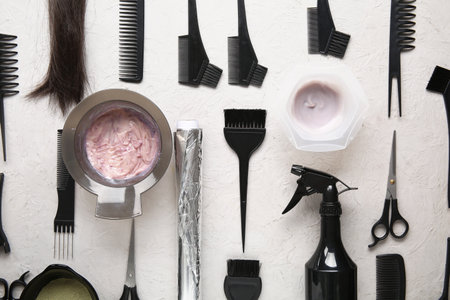 Bowls with hair dye and set of hairdresser's tools on white backgroundの写真素材