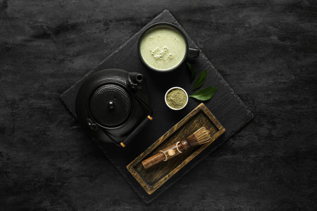 Composition with fresh matcha tea, teapot and chasen on dark backgroundの写真素材