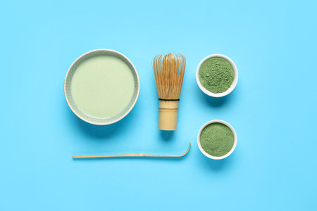 Composition with fresh matcha tea, powder and accessories on color backgroundの写真素材
