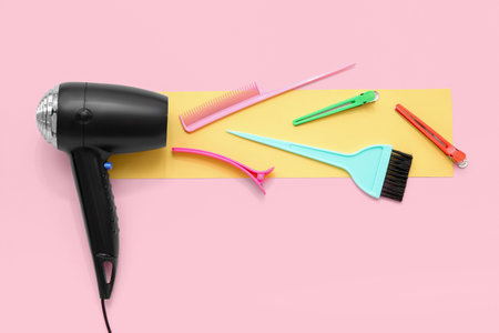 Hair dryer and hairdressing tools on pink backgroundの写真素材