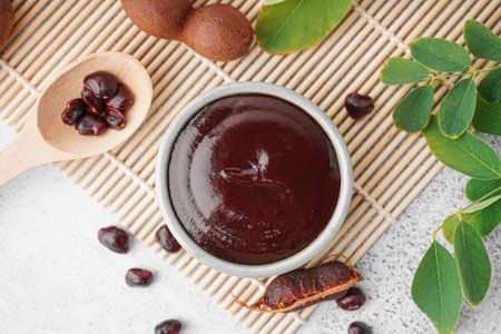Bowl with tasty tamarind jam with fruits on white backgroundの写真素材