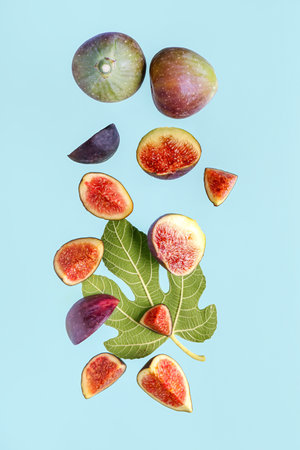 Fresh ripe figs and leaves on blue backgroundの写真素材