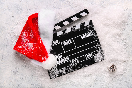Movie clapper with Santa hat and decorative snow on grunge backgroundの写真素材