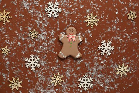 Gingerbread cookies with decorative snow on brown background