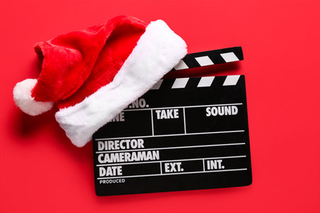 Movie clapper with Santa hat on red backgroundの写真素材