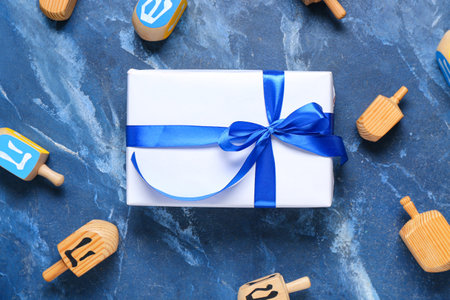Composition with gift box and dreidels for Hanukkah celebration on color backgroundの写真素材