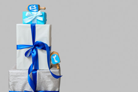 Stack of different gifts for Hanukkah celebration and dreidels on gray backgroundの写真素材