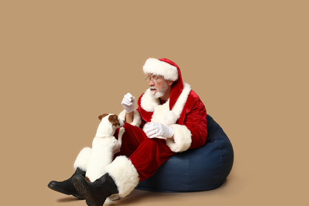 Santa Claus with cute Jack Russell Terrier dog on brown backgroundの写真素材