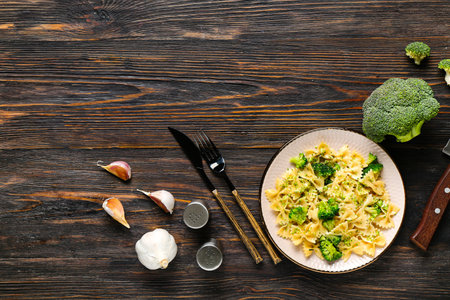 Plate of tasty pasta with broccoli on wooden backgroundの写真素材
