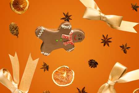 Brown gingerbread cookies with Christmas decor on color background.