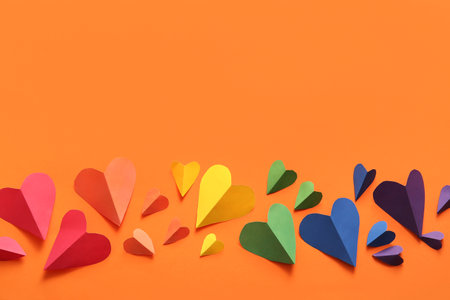 Colorful hearts made of paper on orange background. LGBT conceptの写真素材