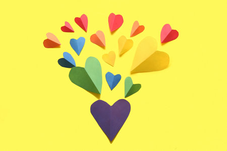 Colorful hearts made of paper on yellow background. LGBT conceptの写真素材