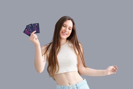 Young woman with credit cards on dark background